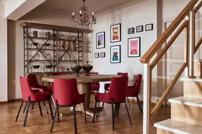 a dining room with a wooden table and red chairs at Plaka's Villa with Breathtaking Acropolis view in Athens