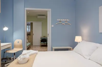 a blue bedroom with a white bed and a desk at Grandma's Chic & Bright Athenian home with a Patio in Athens
