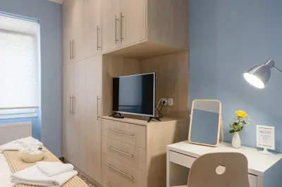 a room with a tv and a desk with a mirror at Grandma's Chic & Bright Athenian home with a Patio in Athens