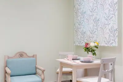 a table and chairs with a vase of flowers on it at Grandma's Chic & Bright Athenian home with a Patio in Athens