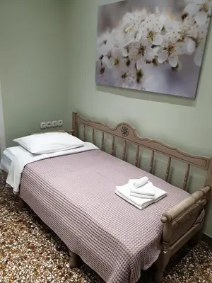 a bed with two white towels on top of it at Grandma's Chic & Bright Athenian home with a Patio in Athens