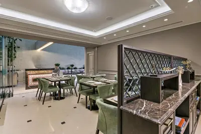 a restaurant with green chairs and tables and a fireplace at Estia Boutique Apartments in Athens