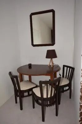 a table with two chairs and a mirror on a wall at Galotel Agnoudas near the airport in Markopoulo