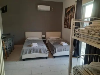 a room with two bunk beds and a window at Galotel Agnoudas near the airport in Markopoulo