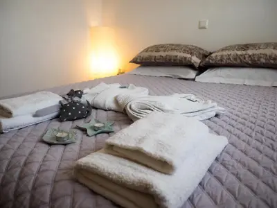 a bed with blankets and towels on top of it at 7th Floor Stunning View Penthouse in Piraeus in Piraeus