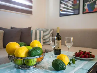 a table with a bowl of fruit and a bottle of wine at 7th Floor Stunning View Penthouse in Piraeus in Piraeus