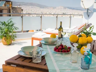a table with plates of fruit on a balcony at 7th Floor Stunning View Penthouse in Piraeus in Piraeus
