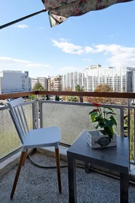a white chair and a table on a balcony at Athens Heartbeat in Athens