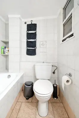 a white bathroom with a toilet and a bath tub at Athens Heartbeat in Athens