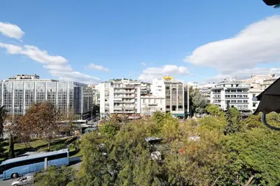 a bus is parked in a city with buildings at Athens Heartbeat in Athens