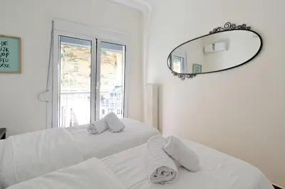 a white bedroom with a bed and a mirror at Athens Heartbeat in Athens
