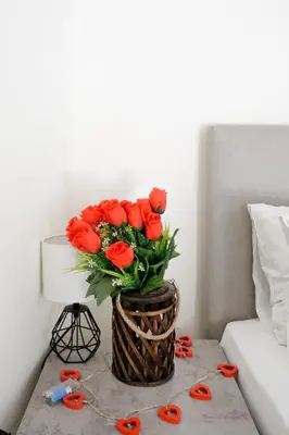 a vase of red roses on a table with scissors at Athens Heartbeat in Athens