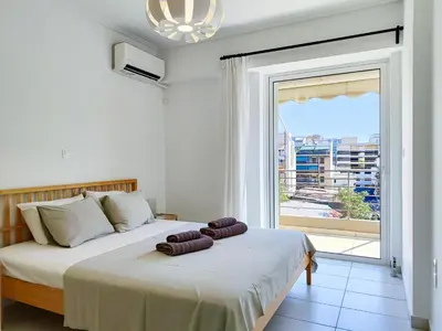 a bedroom with two beds and a large window at KYMA Apartments - Athens Acropolis 14 in Athens