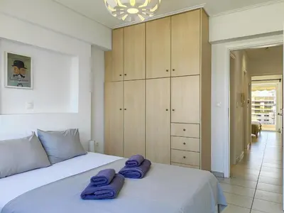 a bedroom with a white bed with purple towels on it at KYMA Apartments - Athens Acropolis 14 in Athens