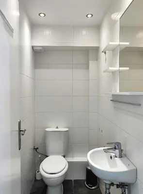 a white bathroom with a toilet and a sink at KYMA Apartments - Athens Acropolis 14 in Athens