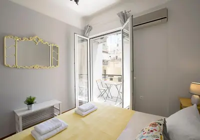a bedroom with a bed with a mirror and a balcony at Attractive Flat near the Acropolis Museum & Metro Station by Athenian Homes in Athens
