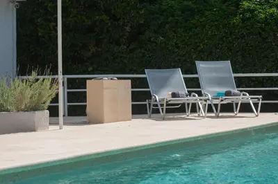 two chairs sitting next to a swimming pool at Stefanakis Hotel & Apartments in Varkiza
