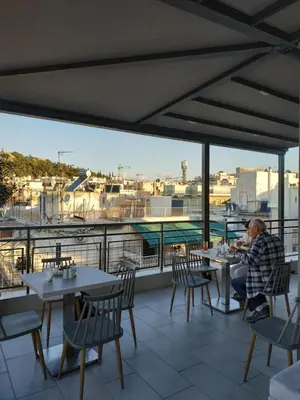 a man sitting at a table on a patio at Hotel @Syngrou Fix in Athens