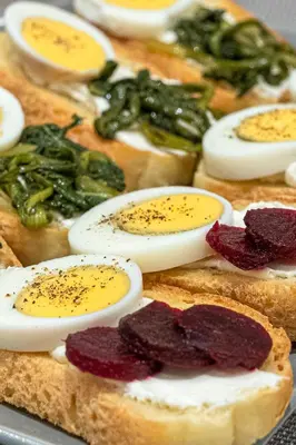 a bunch of bread with eggs and peppers on it at Hotel @Syngrou Fix in Athens