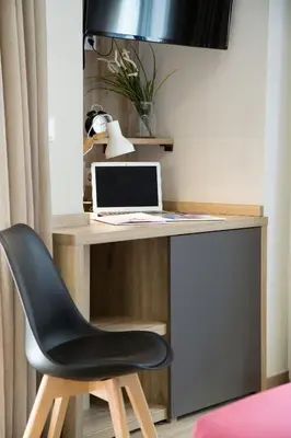 a desk with a laptop and a chair at Hotel @Syngrou Fix in Athens