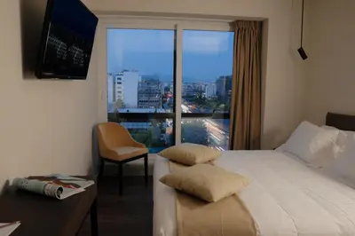 a hotel room with a bed and a large window at B4B Athens 365 in Athens