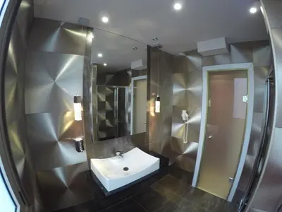 a bathroom with a sink and a mirror at Carol Hotel in Piraeus