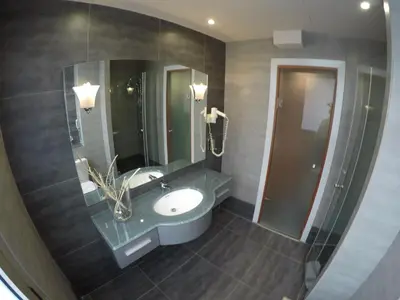 a bathroom with a sink and a mirror at Carol Hotel in Piraeus