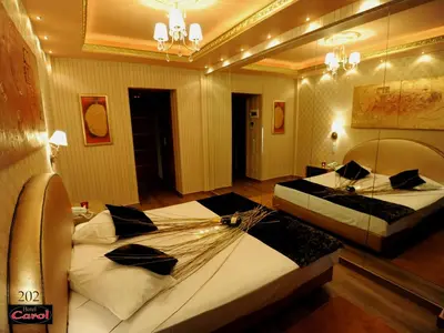 a hotel room with two beds and a mirror at Carol Hotel in Piraeus
