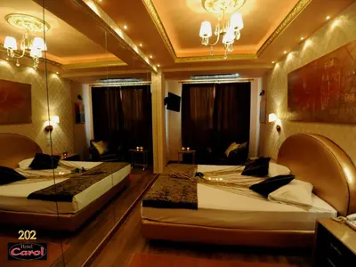 a hotel room with two beds and a couch at Carol Hotel in Piraeus