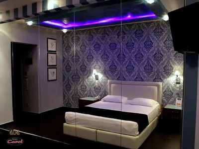 a bedroom with a bed with a purple wall at Carol Hotel in Piraeus
