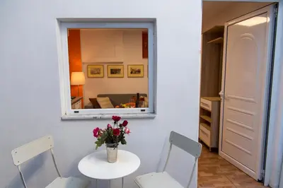 a room with a table with a vase of flowers on it at Ancient Thissio in Athens