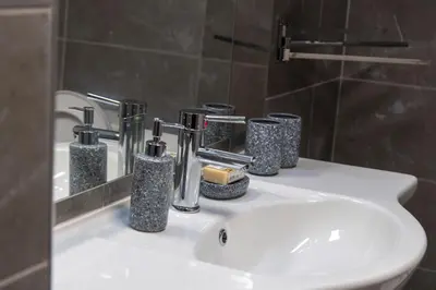 a bathroom sink with four bottles and a mirror at Ancient Thissio in Athens