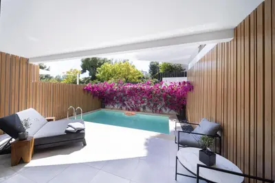 a backyard with a swimming pool and purple flowers at Azur Hotel in Athens