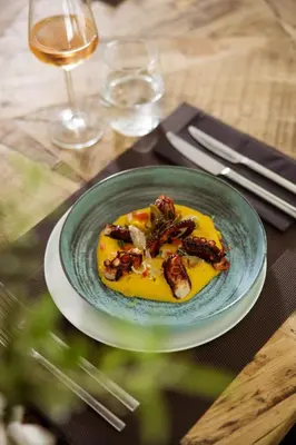 a plate of food on a table with a glass of wine at Azur Hotel in Athens