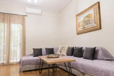 a living room with a purple couch and a table at Quality Home in Athens in Athens