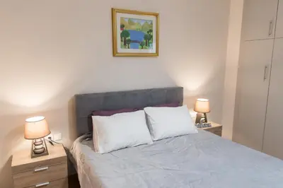 a bedroom with a bed with two night stands and two lamps at Quality Home in Athens in Athens