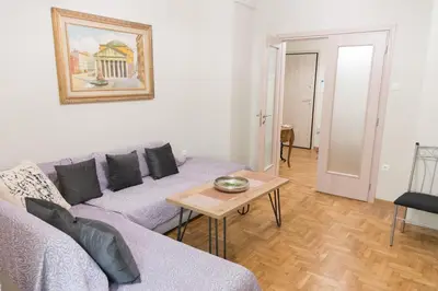 a living room with a couch and a table at Quality Home in Athens in Athens