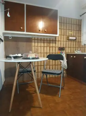 a table and a chair in a kitchen at Violet Bedroom and Apartment in Spáta