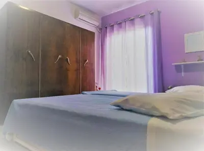 a purple bedroom with a bed and a window at Violet Bedroom and Apartment in Spáta