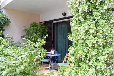 a patio with a blue table and chairs and trees at Violet Bedroom and Apartment in Spáta