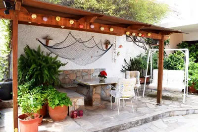 a patio with a table and chairs under a pergola at Violet Bedroom and Apartment in Spáta