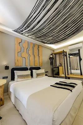 a bedroom with a large bed with white sheets at Mikelina Boutique Hotel in Pallíni