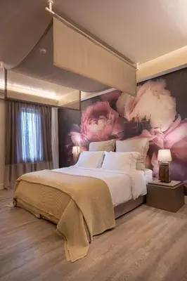 a bedroom with a large bed with flowers on the wall at Mikelina Boutique Hotel in Pallíni