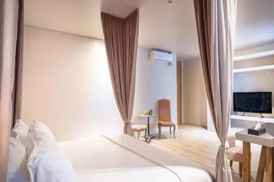 a hotel room with a bed and a television at Mikelina Boutique Hotel in Pallíni