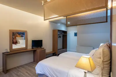 a hotel room with two beds and a television at Mikelina Boutique Hotel in Pallíni
