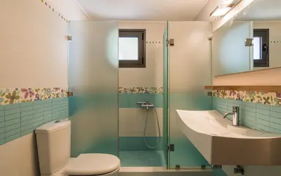 a bathroom with a toilet and a sink and a shower at Adam & Eve Villas in Sounio