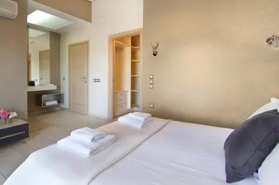 a bedroom with a large white bed with towels on it at Adam & Eve Villas in Sounio