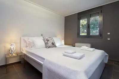 a bedroom with a white bed with towels on it at Adam & Eve Villas in Sounio