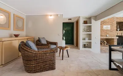 a living room with two chairs and a fireplace at Adam & Eve Villas in Sounio
