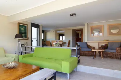 a living room with a green couch and a table at Adam & Eve Villas in Sounio